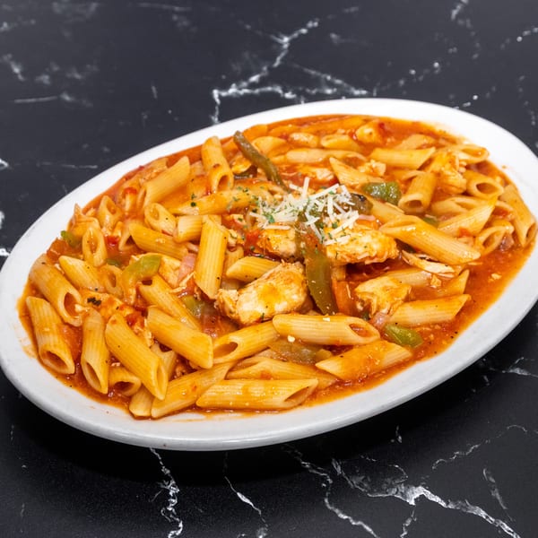 Penne pasta with chicken, green peppers, and red sauce, garnished with cheese and parsley.